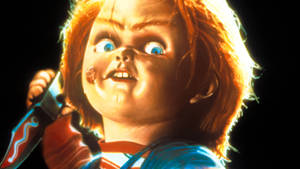 恐怖娃娃 Chucky 手持刀，滿臉鮮血，眼睛睜大。