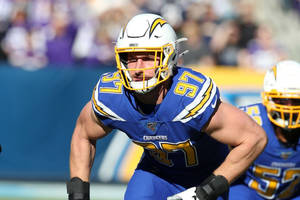 身穿Chargers球衣的NFL足球運動員在比賽期間在場上奔跑。
