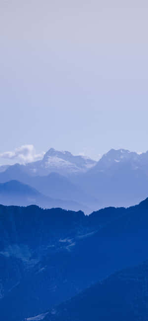 寧靜的山脈，白雪覆蓋的山峰，朦朧藍天下。 — 漸變動畫 壁紙