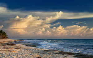 熱帶海灘日落，金色雲彩和拍岸海浪。