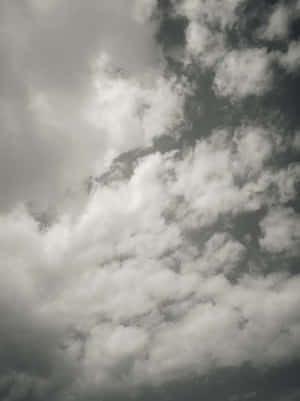 戲劇性的天空，充滿蓬鬆的白雲，背景為灰色。