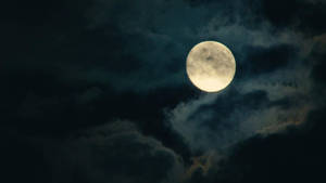 滿月穿過夜間的烏雲閃耀 — 月色夜空 壁紙