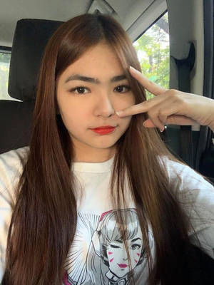 年輕女性在車內做出和平手勢，穿著圖案T恤