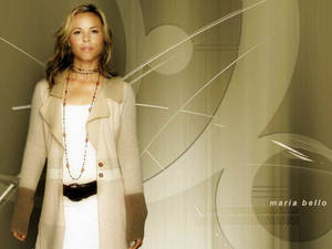 Maria Bello 身穿米色外套站在抽象背景前 — 荷里活 GIF 壁紙
