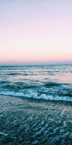 日落時分的海浪，帶有粉紅色和藍色色調