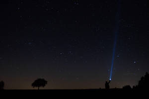 人手持電筒指向夜空中的星星