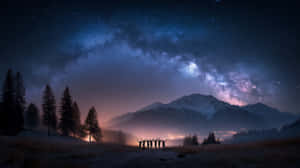一群人在星空下舉起雙臂，背景是積雪的山峰和松樹。