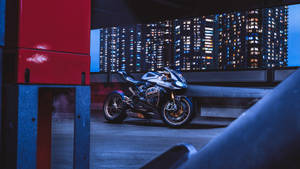 時尚銀色Ducati電單車停泊在天台，背後是發光的城市天際線。