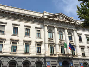 陽光明媚的日子裡，旗幟飄揚的歷史意大利銀行建築。 — 建築 壁紙