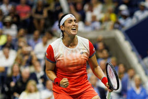 身穿紅色運動服的網球選手握緊拳頭、歡呼勝利。 — 網球 壁紙
