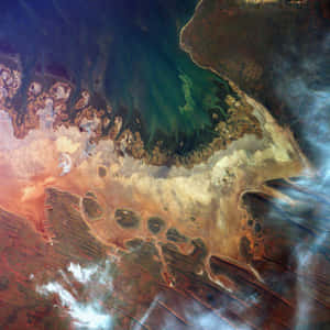 色彩繽紛的海岸線衛星圖，呈現綠色海水與鏽色陸地。 — iPad 第10代 壁紙