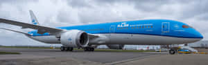 荷蘭皇家航空飛機在機場停機坪上，天空多雲