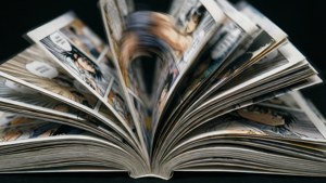 打開的漫畫書，扇狀展開的頁面顯示動漫角色和對話氣泡。 — 漫畫 壁紙