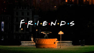 夜晚城市前，「FRIENDS」標誌下的橙色沙發和燈具。