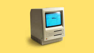 米色復古 Macintosh SE 電腦，藍色屏幕，黃色背景。