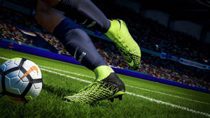 足球運動員的螢光綠色球鞋即將在體育場球場上踢Nike球。