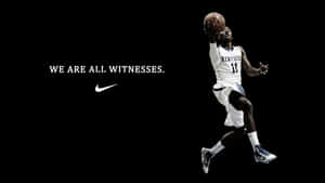籃球運動員在半空中手持帶有Nike標語的籃球，背景為黑色 — 籃球 壁紙