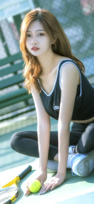 年輕女子跪在網球場上，手持球，球拍在附近。 — 型格 Nike 壁紙
