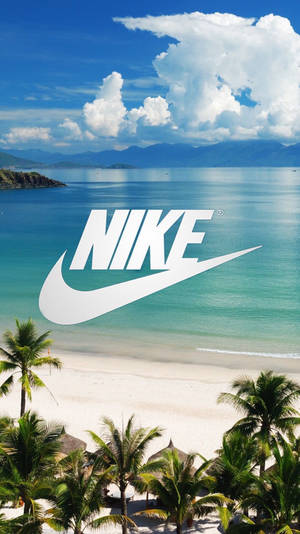 熱帶海灘，有棕櫚樹和山脈，在藍天下有一個大型白色Nike標誌。