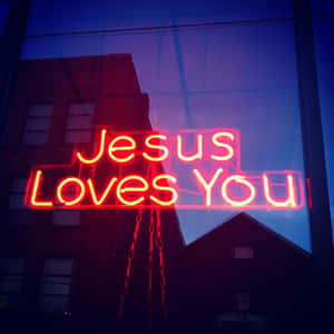 夜晚窗戶上寫著 Jesus Loves You 的紅色霓虹燈牌。
