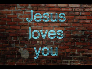 藍色霓虹燈牌寫著 Jesus loves you 在磚牆上。 — 耶穌基督 壁紙