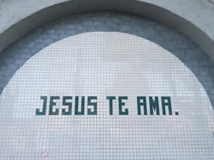 一個瓷磚拱門，上面用綠色瓷磚寫著「Jesus te ama」的信息。