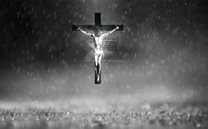 雨中的發光 crucifixion 人物，光線射向霧氣瀰漫的田野。 — 黑白 壁紙