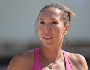 專注的女運動員穿著粉紅色運動上衣在戶外日光下。 — 網球 壁紙
