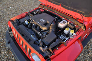 紅色Jeep Wrangler打開引擎蓋，在碎石上展示柴油引擎。