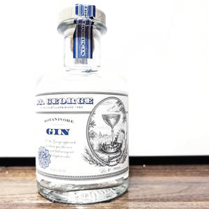 St George Botanivore Gin 酒瓶放在木質表面上，背景為白色。