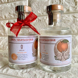 兩瓶 St George Atlas Orange Gin，其中一瓶在石面上用紅色絲帶綁著。