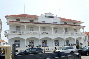 白色殖民建築，紅色屋頂，街上停有汽車