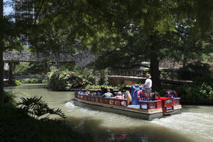 觀光船載著乘客在陰涼的城市運河中航行，途經石橋。 — 旅行 壁紙