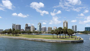 從海濱公園看到的城市天際線，有棕櫚樹和人沿著邊緣行走。