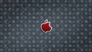 灰色雪花圖案背景上帶有白色縫線的紅色Apple標誌。