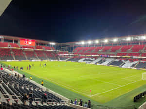 足球場的夜景，球員在場上熱身。