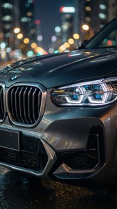 夜間城市中，銀色BMW SUV前格柵和頭燈的特寫。