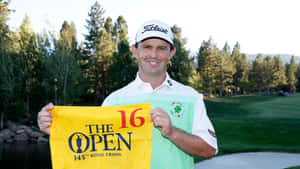 高爾夫球手在陽光明媚的高爾夫球場第16洞舉起The Open 145th Royal Troon旗幟。