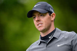 高爾夫球手Rory McIlroy戴著深色帽子和灰色Polo衫在戶外。 — 運動 壁紙