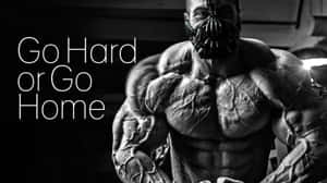 一個肌肉發達的男子戴著蝙蝠面具，旁邊有「Go Hard or Go Home」的文字。