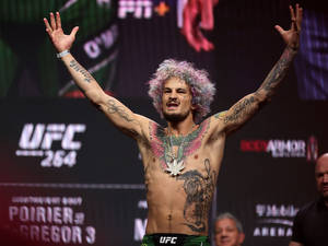 UFC拳手，彩色頭髮和紋身，在稱重時慶祝勝利。