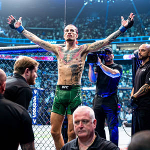 MMA拳手喺八角籠內舉起雙臂慶祝勝利