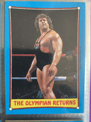 摔角手在擂台上，下方有「The Olympian Returns」橫幅。