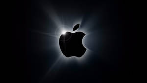 Apple標誌在黑色背景上發光，帶有鏡頭光暈