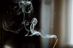 在黑暗房間中，細薄的白煙香薰在柔和背景光中升起。 — 迷霧森林 壁紙