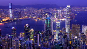 夜晚的香港天際線，燈火通明的摩天大樓和港口