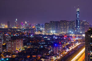 夜間城市，有燈光建築物和移動車輛的光跡。 — 唐人街 GIF 壁紙