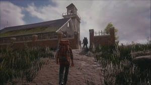 兩名遠足者在黃昏時分穿過高草接近一座古老的木造教堂。