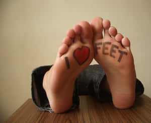 腳底畫有「I heart feet」字樣的腳擱在木頭上。