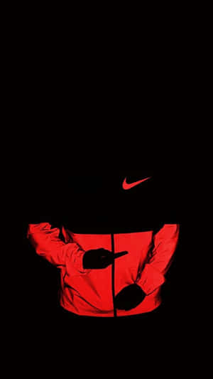 黑色背景上，手指向前方嘅紅色Nike外套剪影。